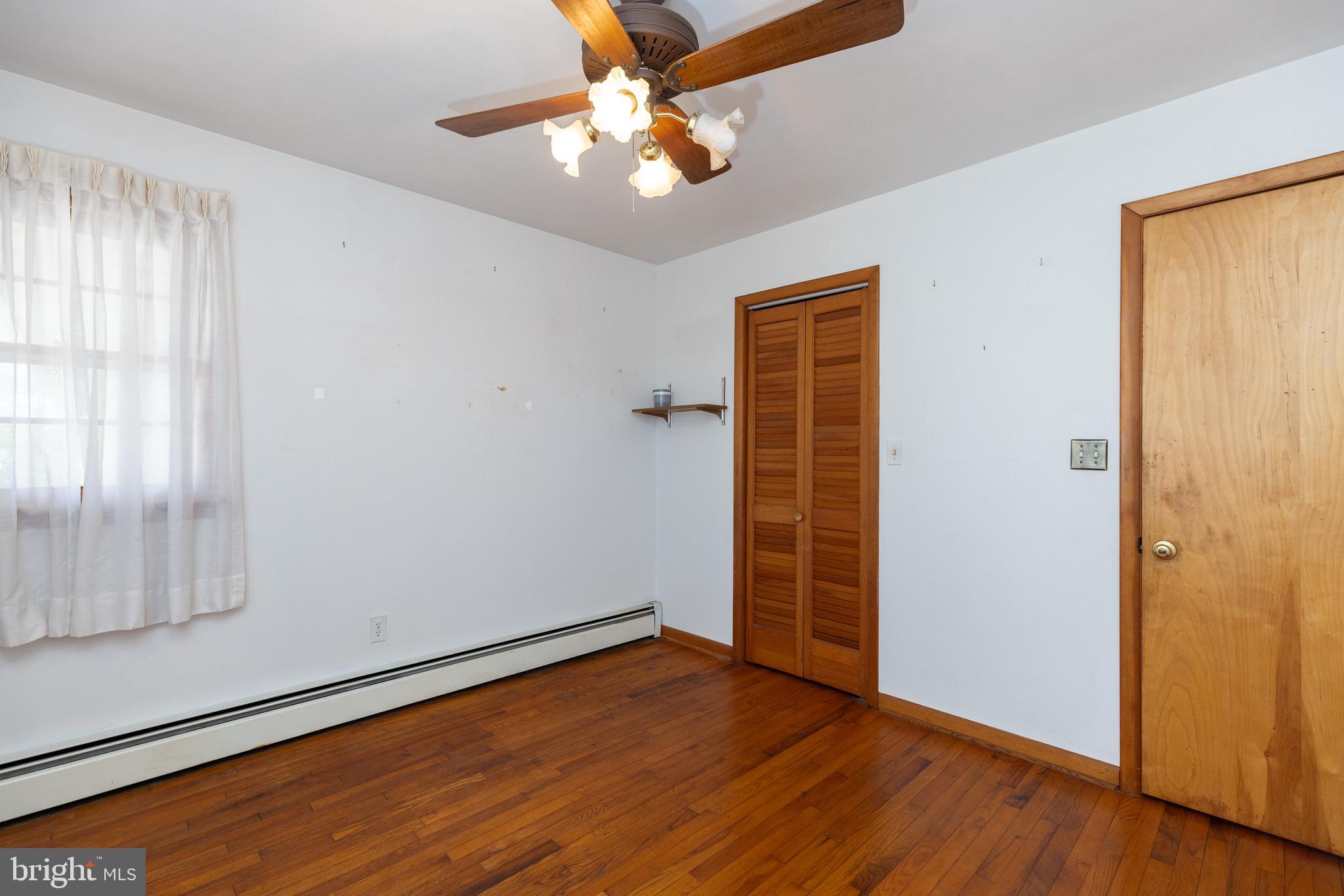 31360 Point Circle Lewes, DE 19958 - Photo 13 of 42 an empty room with wooden floor chandelier fan and windows