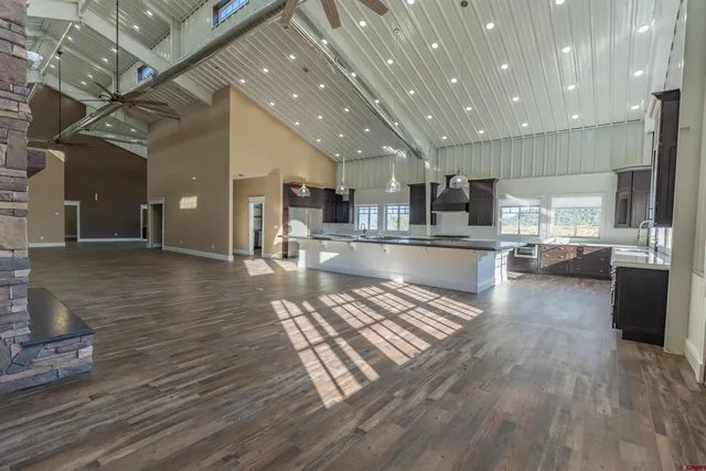 an open kitchen view with wooden floor and stainless steel appliances