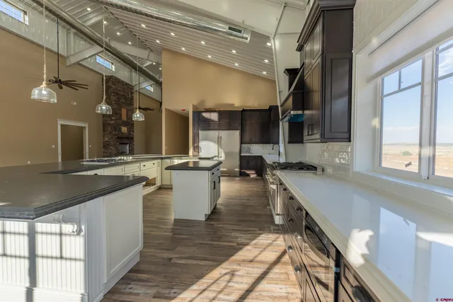 a large kitchen with stainless steel appliances kitchen island a large counter top and a view of living room