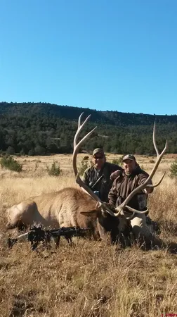 a kitchen with stainless steel appliances kitchen island granite countertop a refrigerator a stove a dining table and chairs with wooden floor