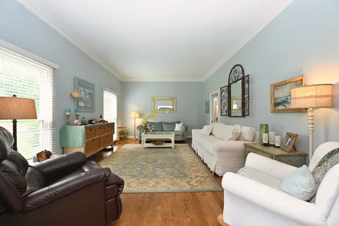 a living room with furniture a fireplace and a chandelier