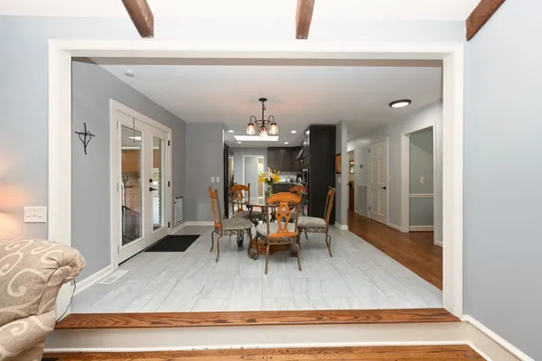 a view of a dining room with furniture a chandelier and wooden floor
