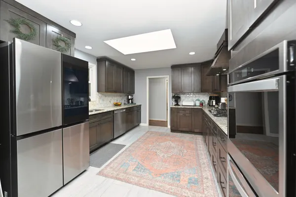 a kitchen with stainless steel appliances granite countertop a sink stove and refrigerator