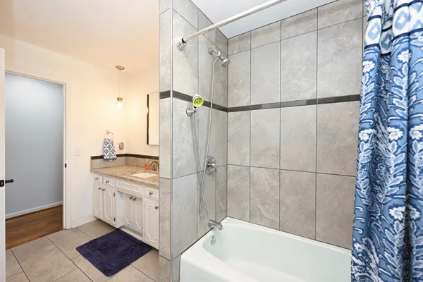 a bathroom with a granite countertop sink mirror and shower