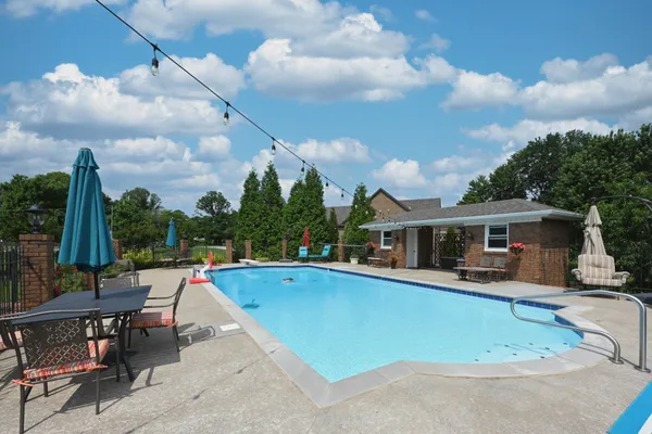a view of swimming pool with outdoor seating and a yard