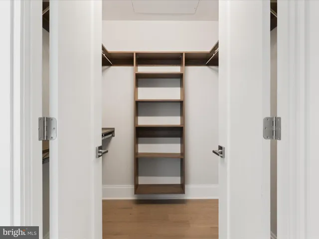 a view of walk in closet with empty racks