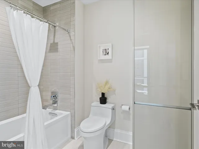 a white toilet sitting next to a bath tub