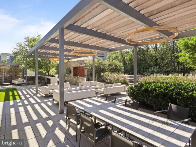 a view of a patio with table and chairs potted plants and floor to ceiling window