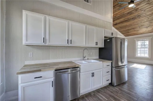 a kitchen with granite countertop a stove and white cabinets
