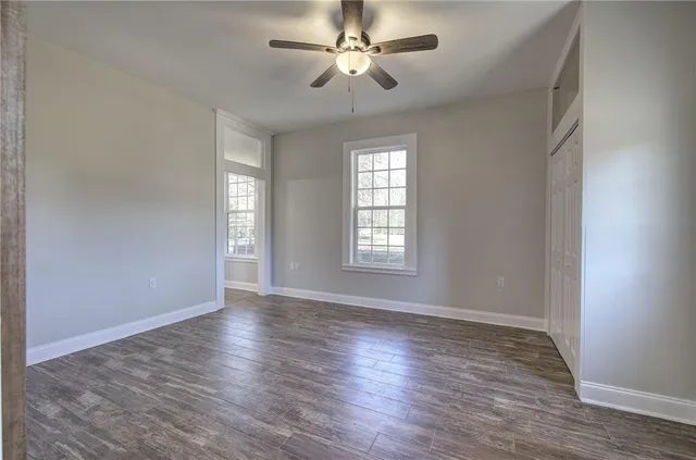 a view of a hallway with wooden floor and staircase