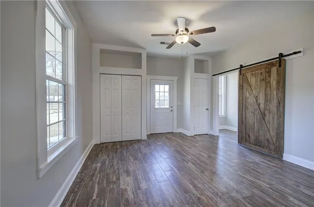 a bathroom with a granite countertop sink toilet a large mirror and a window