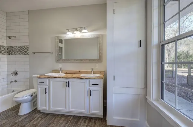 a bathroom with a granite countertop sink a toilet and a mirror