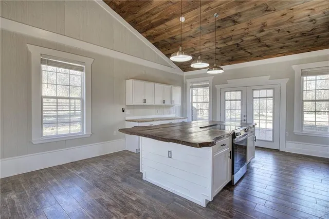 an open kitchen with granite countertop a stove and wooden floor