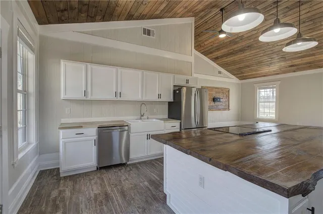 a kitchen with a stove a sink and wooden floor