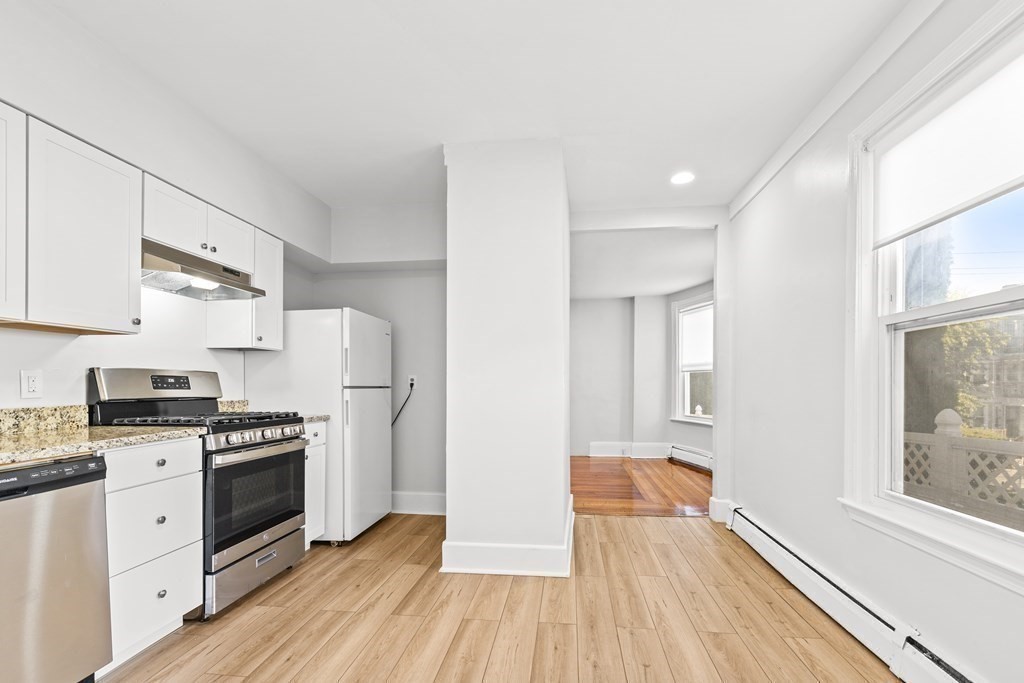 27 Bailey Street Boston, MA 02124 - Photo 25 of 35 a kitchen with wooden floors and white appliances