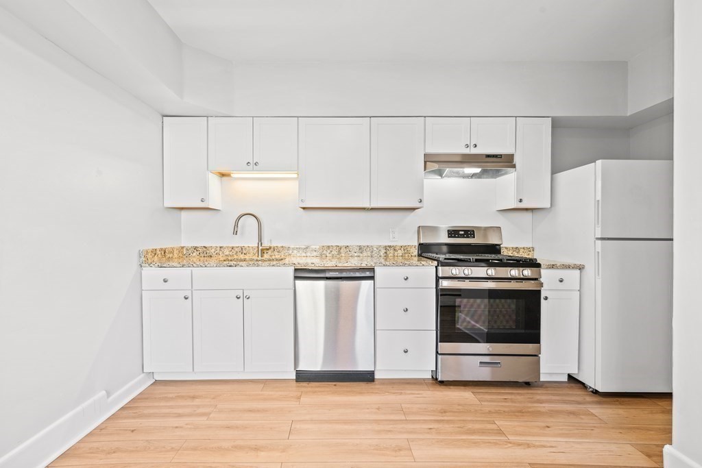 27 Bailey Street Boston, MA 02124 - Photo 26 of 35 a kitchen with stainless steel appliances granite countertop a refrigerator stove and white cabinets