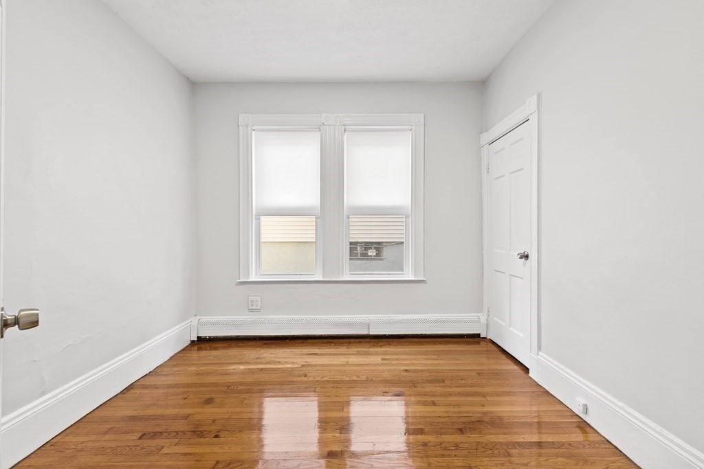 27 Bailey Street Boston, MA 02124 - Photo 27 of 35 a view of an empty room with wooden floor and a window