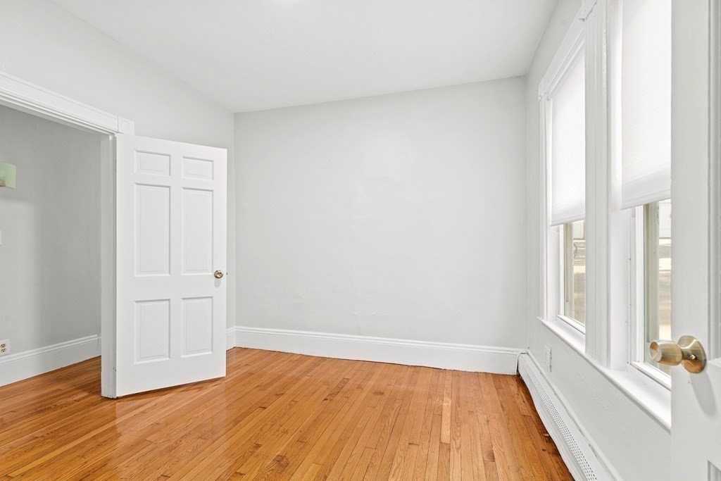 27 Bailey Street Boston, MA 02124 - Photo 29 of 35 an empty room with wooden floor and windows