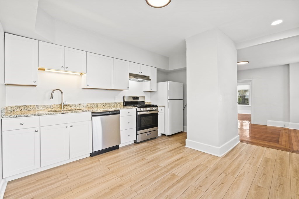 27 Bailey Street Boston, MA 02124 - Photo 6 of 35 a kitchen with granite countertop white cabinets and white appliances