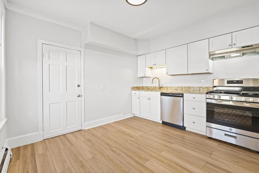 27 Bailey Street Boston, MA 02124 - Photo 7 of 35 a kitchen with granite countertop white cabinets and white appliances