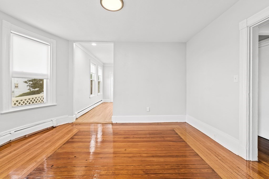 27 Bailey Street Boston, MA 02124 - Photo 8 of 35 a view of an empty room with wooden floor and a window