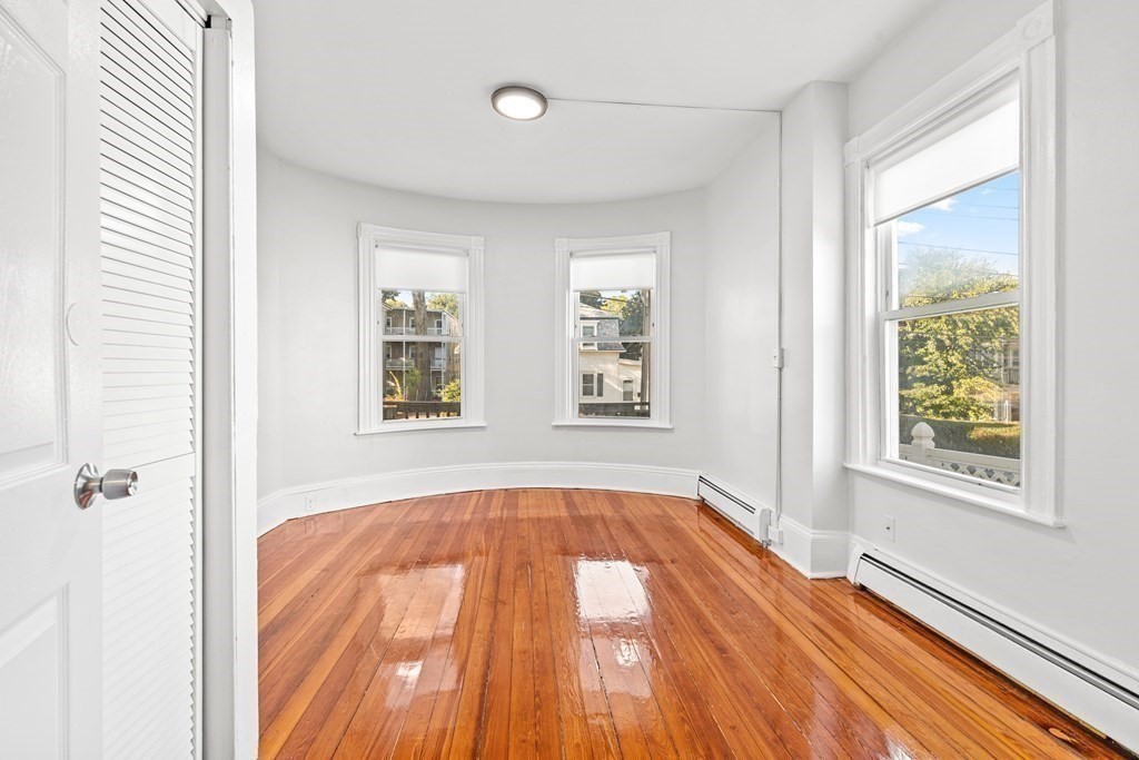 27 Bailey Street Boston, MA 02124 - Photo 9 of 35 a view of an empty room with wooden floor and a window