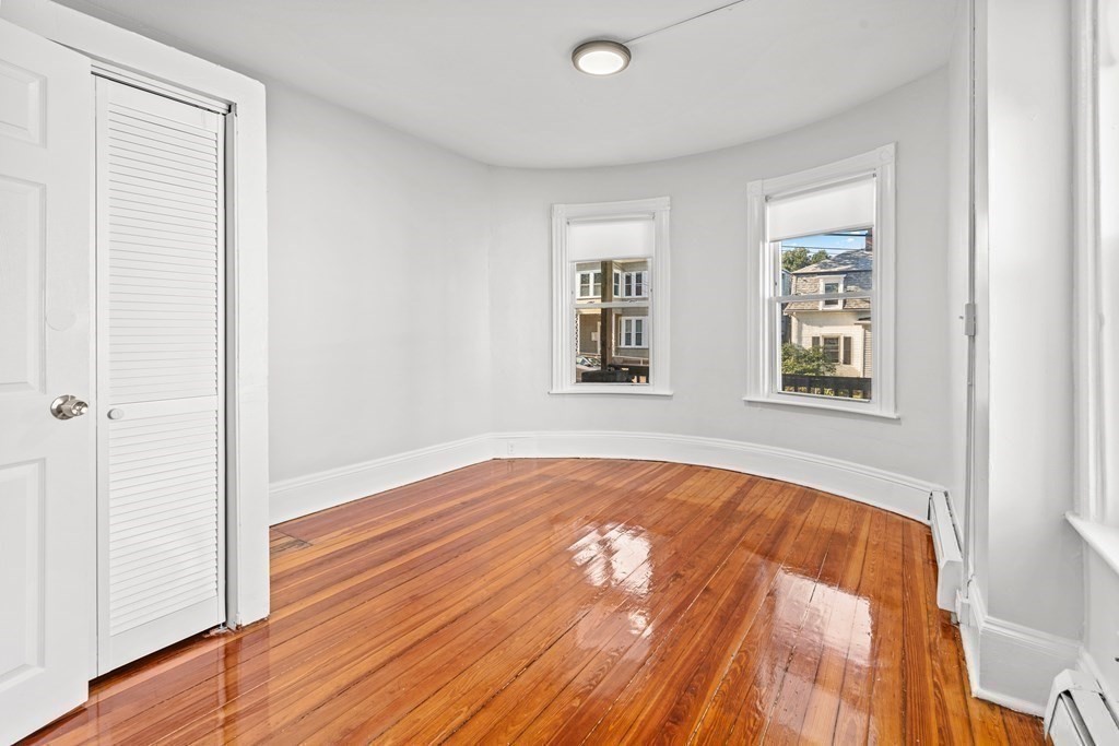 27 Bailey Street Boston, MA 02124 - Photo 10 of 35 a view of an empty room with wooden floor and a window