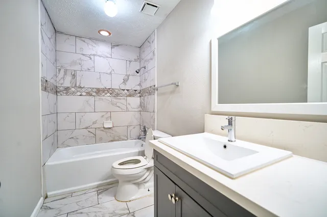 a bathroom with a sink toilet tub and shower
