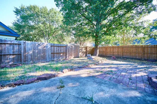 a backyard of house with a small yard and wooden fence