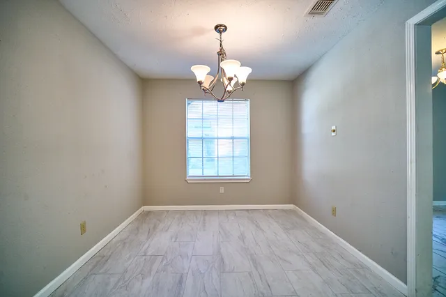 a view of a room with wooden floor chandelier and window