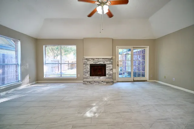 an empty room with fireplace and windows