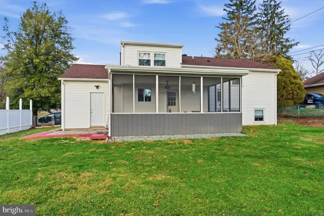 a view of a house with a yard and sitting area