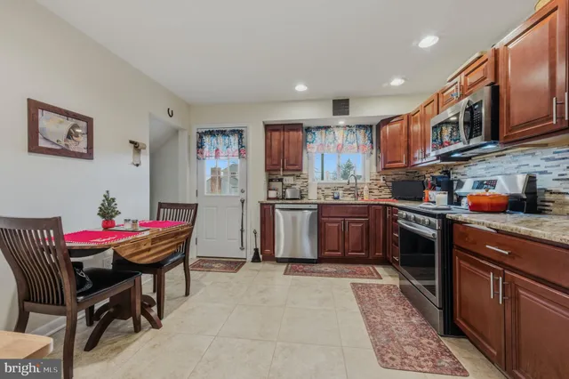 a kitchen with stainless steel appliances kitchen island granite countertop a sink and cabinets