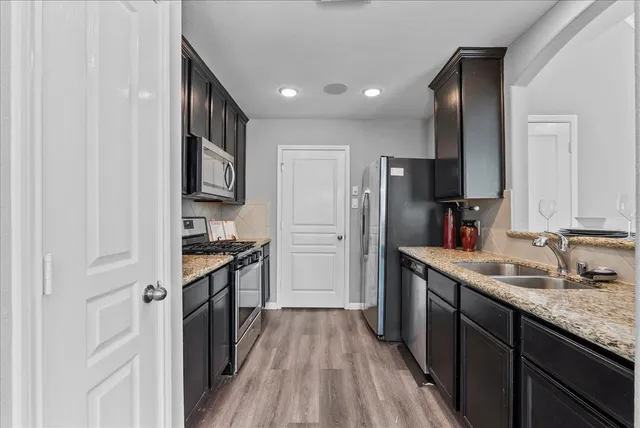 a kitchen with stainless steel appliances granite countertop a refrigerator and a sink