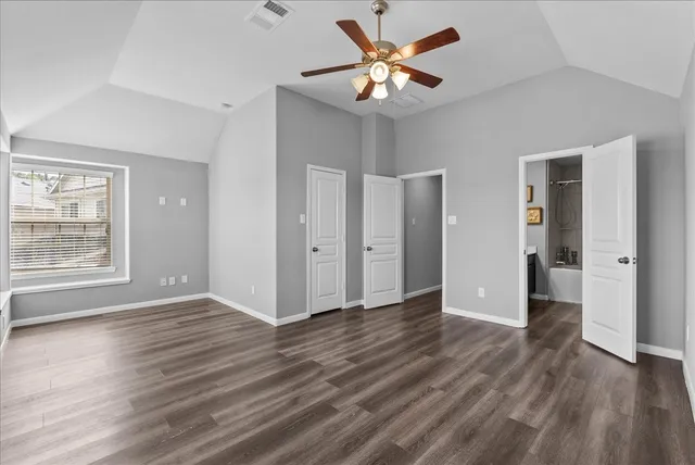 an empty room with wooden floor and a ceiling fan