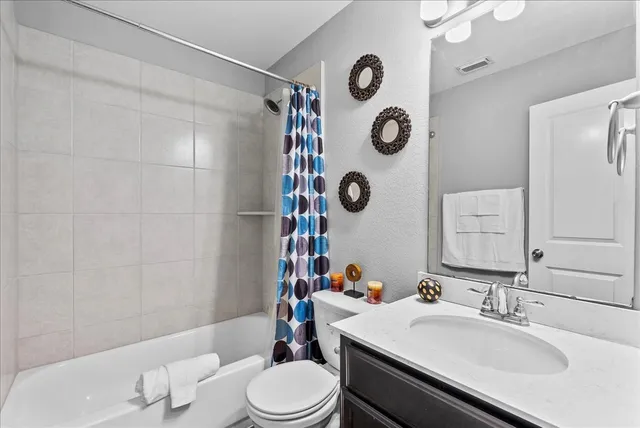 a bathroom with a sink mirror vanity and toilet