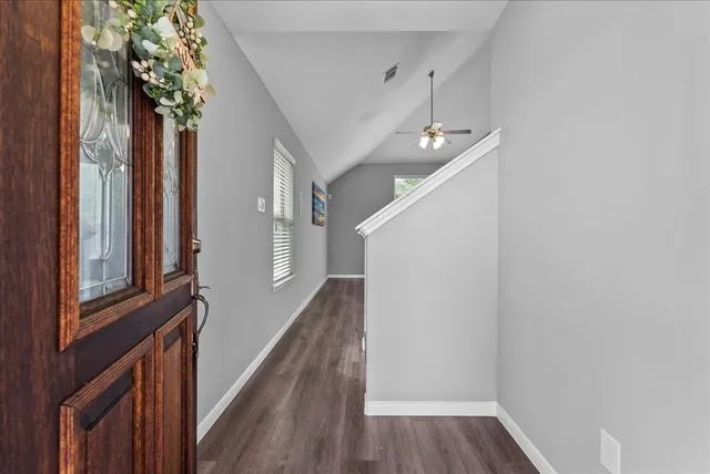 a view of a hallway with wooden floor and staircase