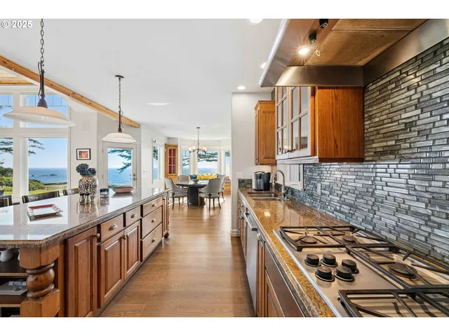 a kitchen with stainless steel appliances granite countertop a stove a sink dishwasher and cabinets with wooden floor