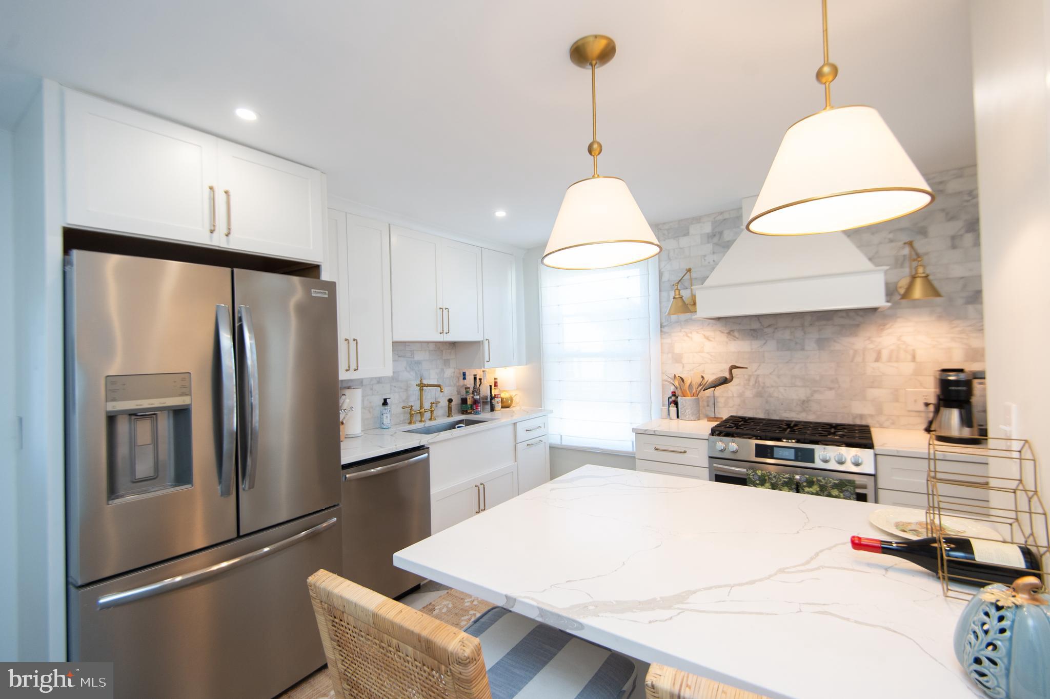 533 South Street Easton, MD 21601 - Photo 23 of 47 a kitchen with kitchen island a counter and a refrigerator