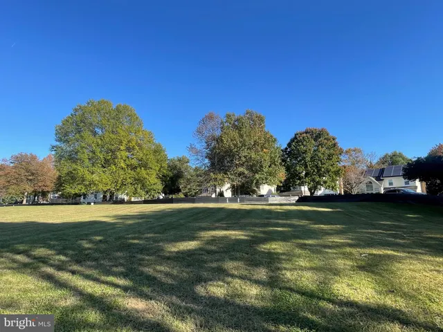 a view of a fountain in front of a house with a big yard