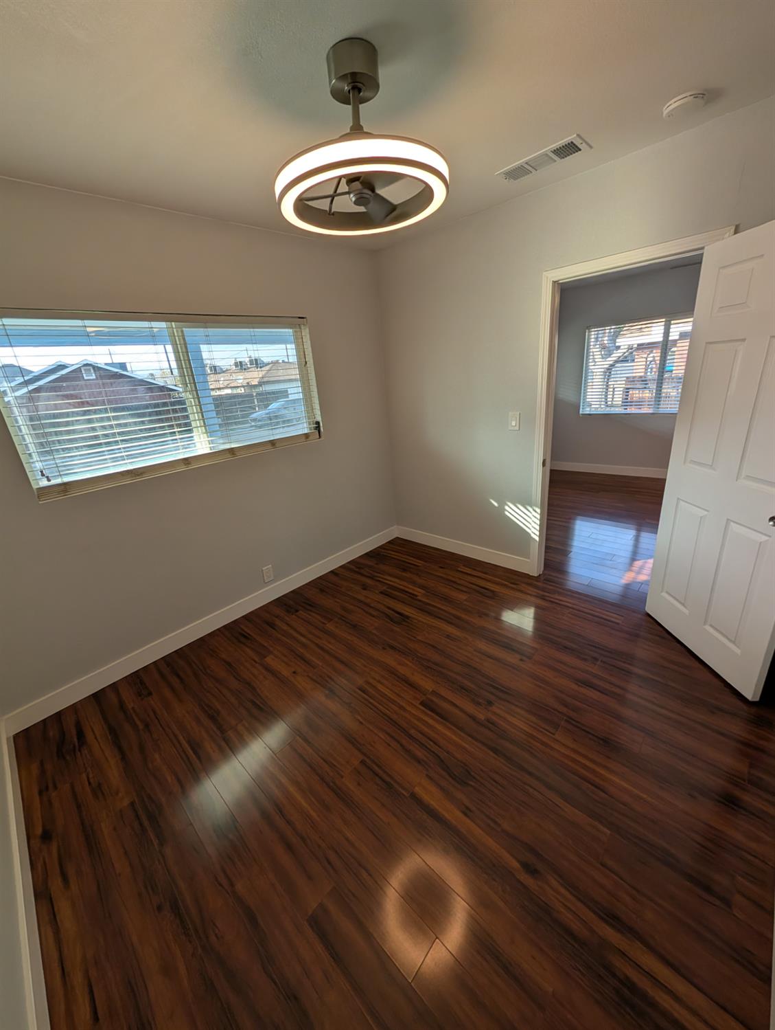 512 Sunset Street Coalinga, CA 93210 - Photo 13 of 24 a view of empty room with wooden floor and fan