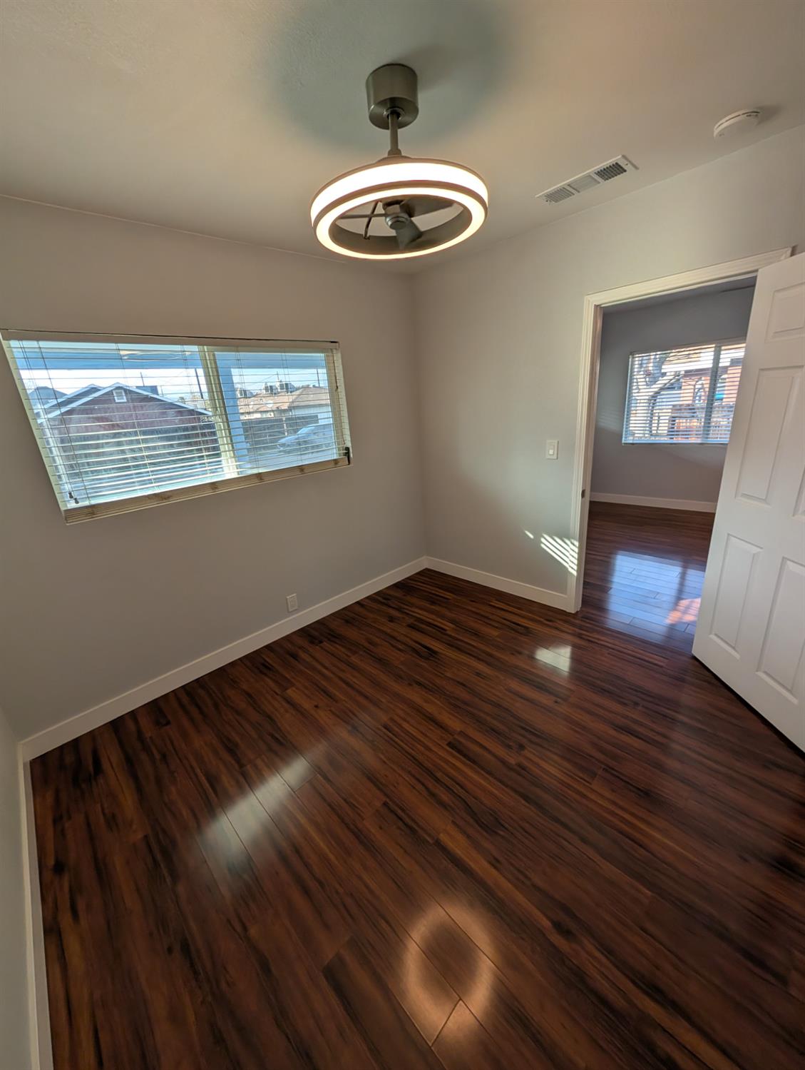 512 Sunset Street Coalinga, CA 93210 - Photo 14 of 24 a view of an empty room with wooden floor and a window