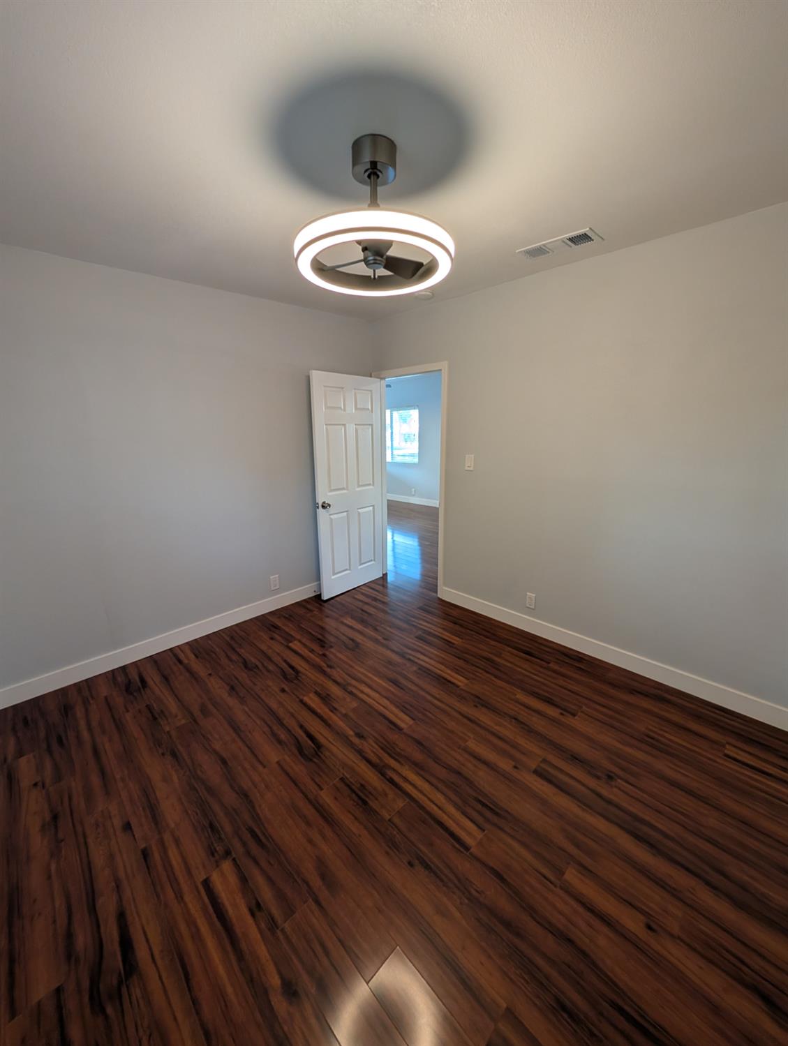 512 Sunset Street Coalinga, CA 93210 - Photo 22 of 24 a room with wooden floor and ceiling fan