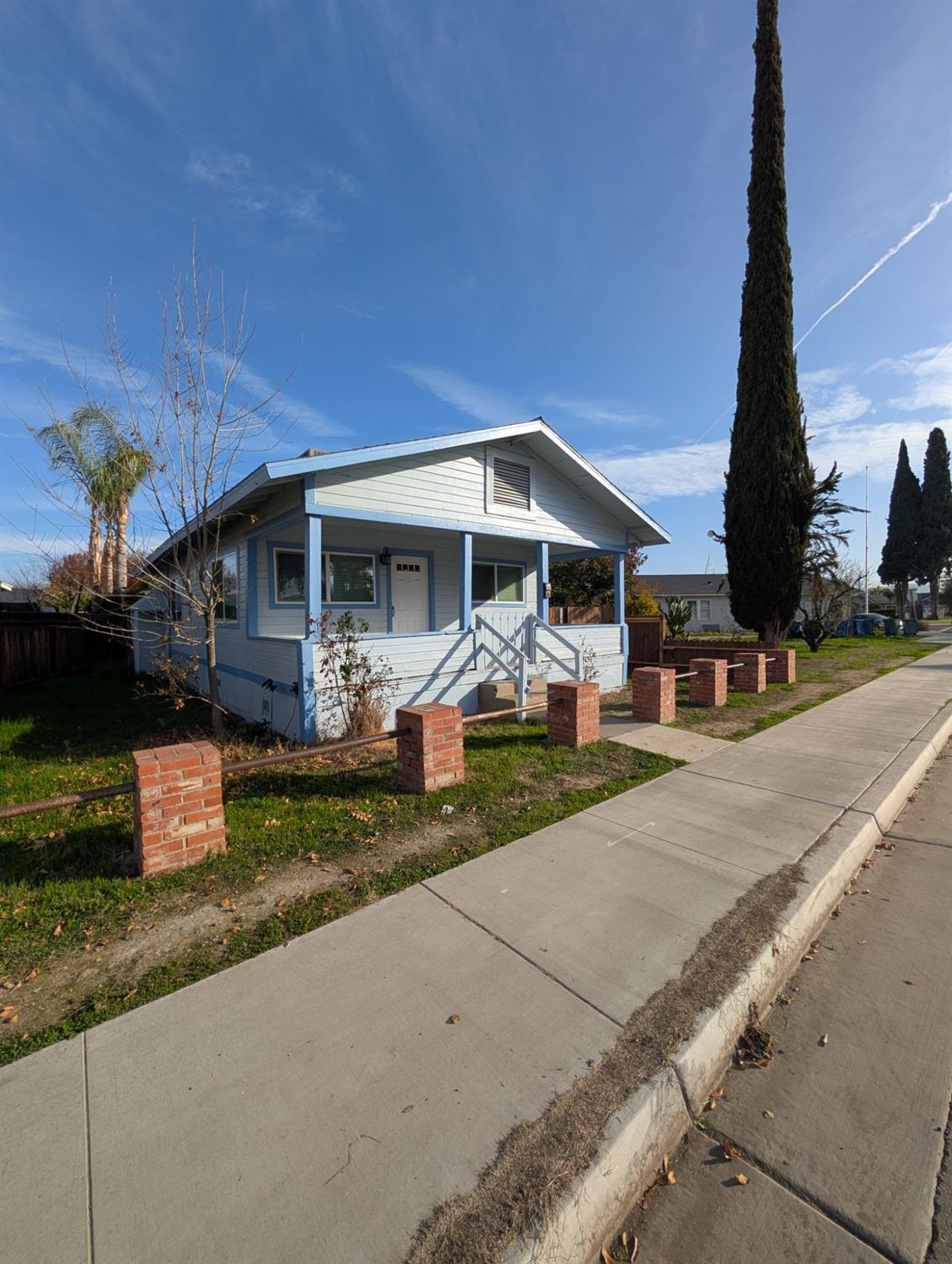 512 Sunset Street Coalinga, CA 93210 - Photo 7 of 24 a front view of a house with a yard and table and chairs