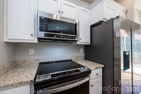 a kitchen with stainless steel appliances granite countertop a stove and a microwave