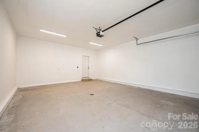 an empty room with an entryway and chandelier fan
