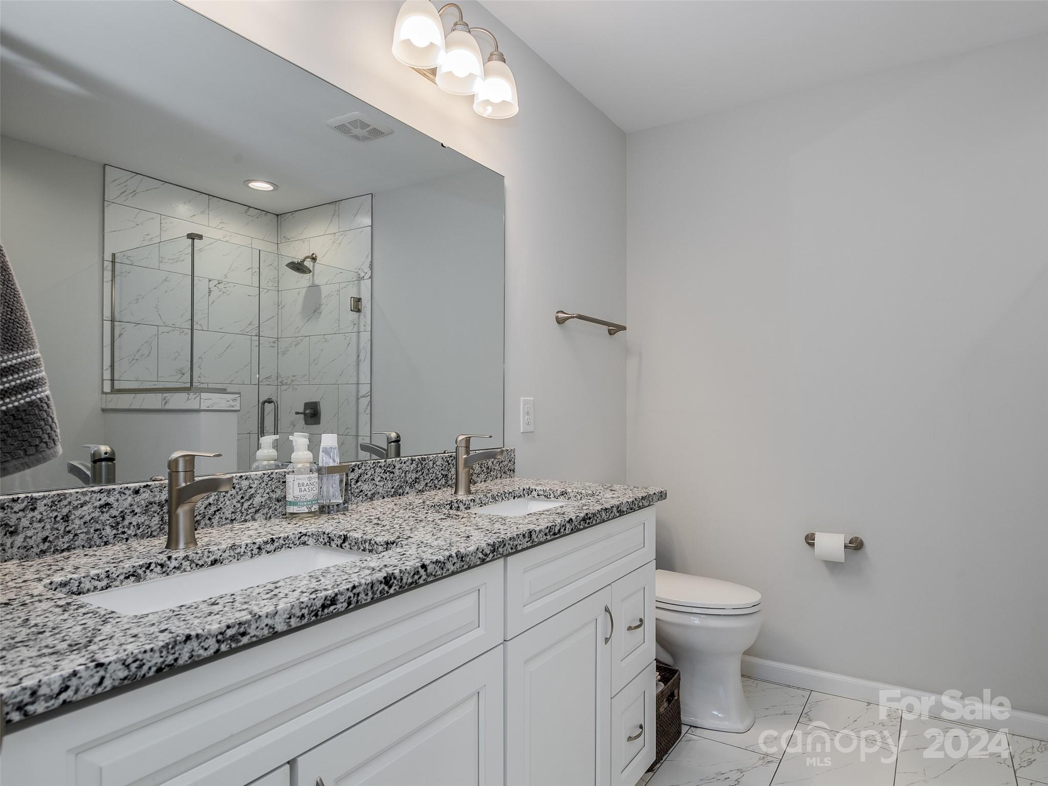 1122 Rhyne Road Charlotte, NC 28214 - Photo 12 of 22 a bathroom with a granite countertop sink a toilet and a mirror