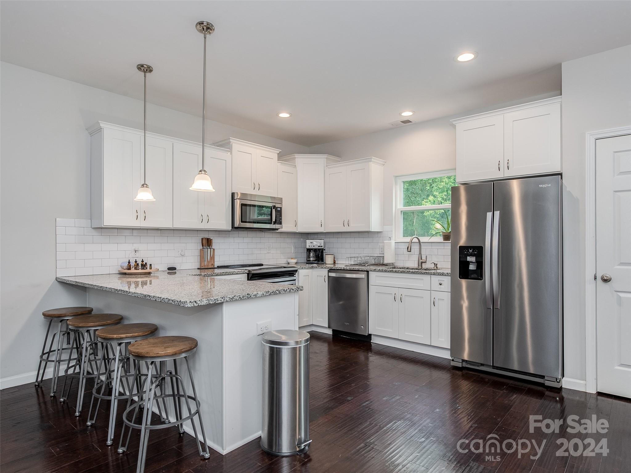 1122 Rhyne Road Charlotte, NC 28214 - Photo 3 of 22 a kitchen with stainless steel appliances granite countertop a refrigerator a sink dishwasher a stove and white cabinets with wooden floor