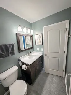 a bathroom with a toilet sink and mirror