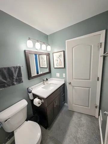 a bathroom with a toilet sink and mirror